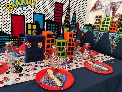 Tischdekoration Superhelden Bunte Kindergeburtstagstafel mit Superhelden-Thema und Gebäudemodellen.