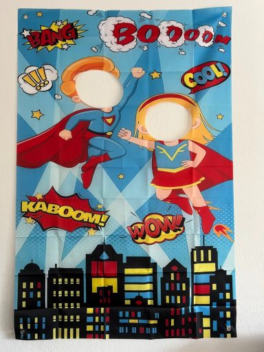 Fotowand Superhelden Ein Förderbanner mit zwei Superhelden in dynamischen Posen vor einer Stadtlandschaft.