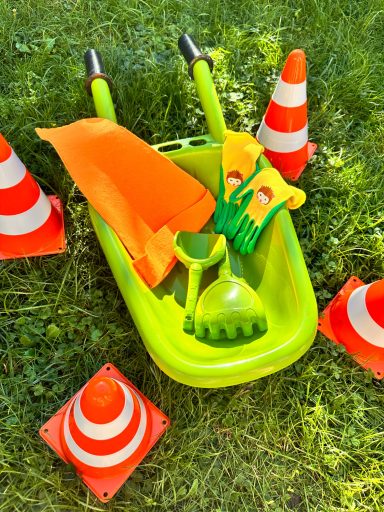 Zwergengeburtstag Schubkarre Kinder Schubkarre und Pylonen auf grünem Gras angeordnet für den Gartenzwerge Kindergeburtstag.