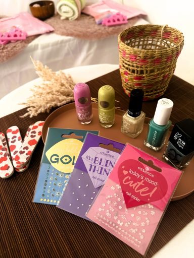 Nagellackflaschen und Pflegeprodukte auf einem Tisch, dekoriert mit einem Korb. Spa Party 