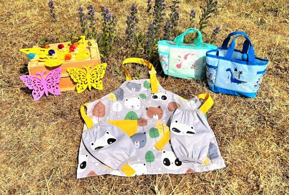 Gartenschürze und Gartenwerkzeuge für jedes Kind Bunte Taschen und eine Schürze mit Tiermotiven für den Gartenzwerge Kindergeburtstag.