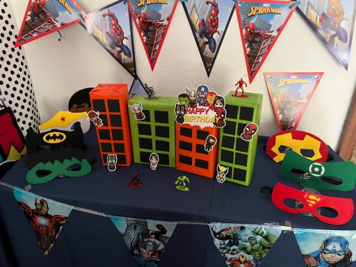 Superhelden Masken Bunte Superhelden-Dekoration mit Masken und Figuren auf einem Tisch.