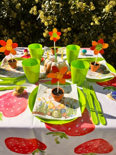 Beispiel Geburtstagstisch Gartenzwerge Bunte Kindergeburtstag Tischdeko mit Blumen, grünen Bechern und Erdbeer-Motiv für den Zwergengeburtstag.